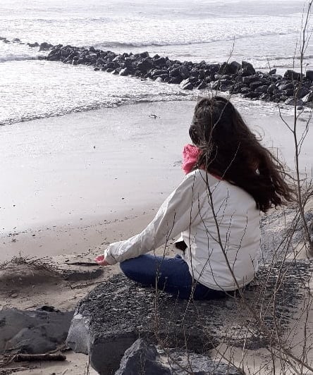 Personne méditant sur la plage