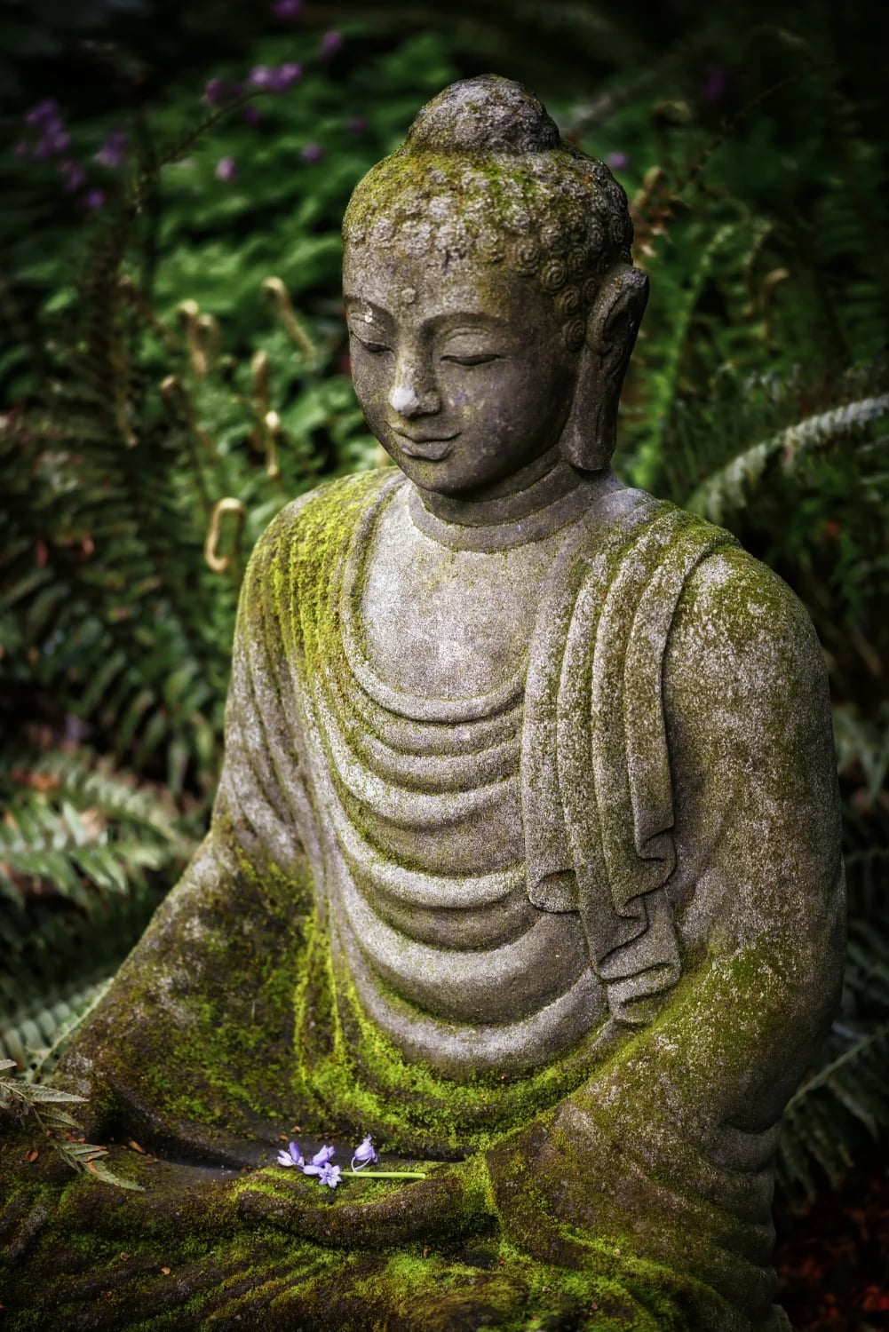 Statue du Bouddha Gautama assis en posture du lotus, les yeux mi-clos, un sourire serein sur les lèvres