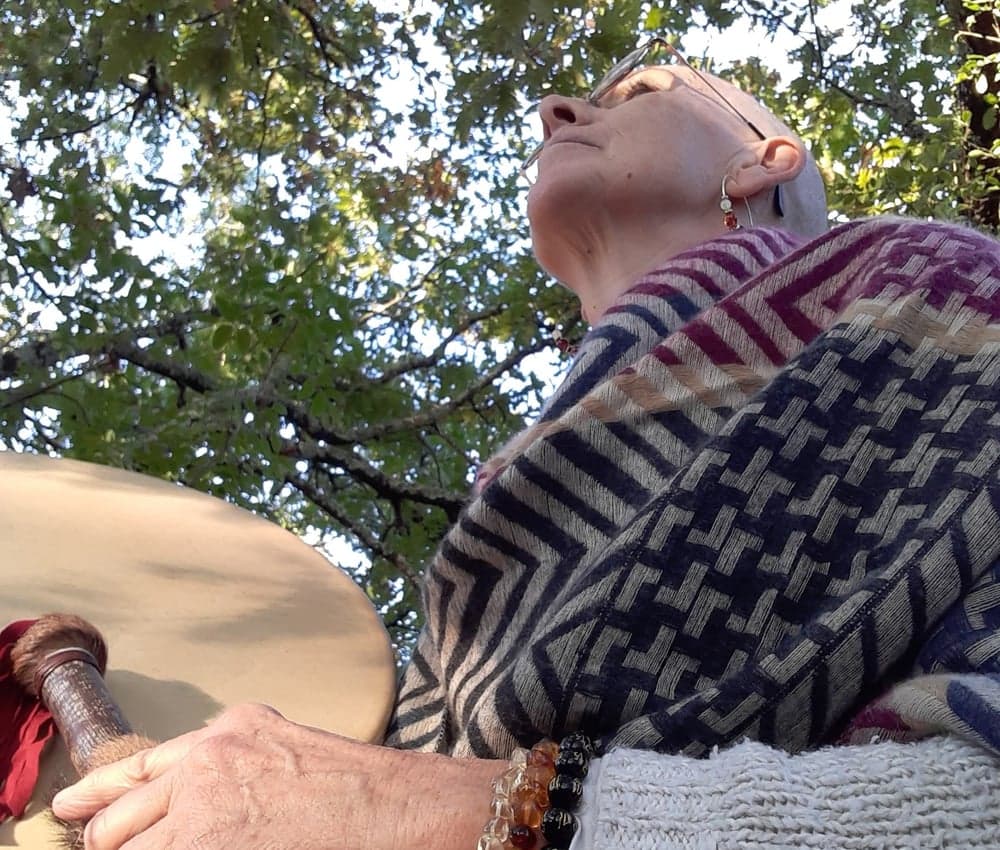 Portrait de Colette, Femme Médecine, tenant un tambour chamanique, vêtue d'un châle aux motifs géométriques